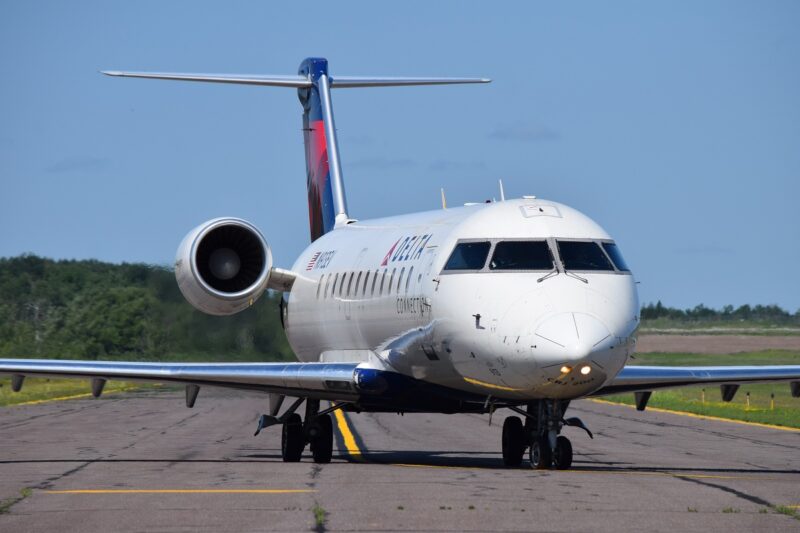Delta airlines jet on runway in Duluth Minnesota with blue sky in background.
